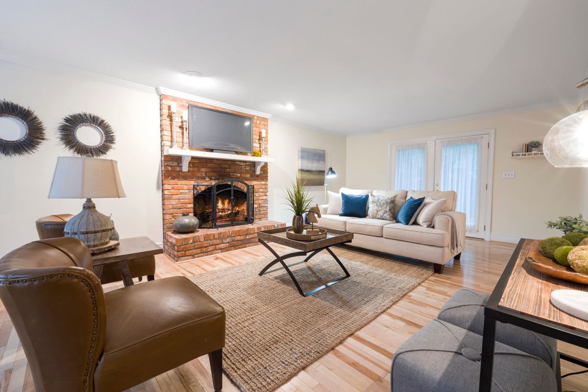 A bright, comfortable living room with a brick fireplace